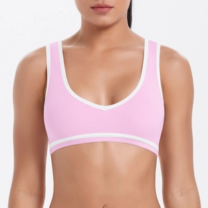 Détail du soutien-gorge de sport rose avec bordure blanche et dos nageur respirant