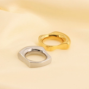 Minimalist 18k gold and silver irregular wavy thick rings on soft beige satin fabric