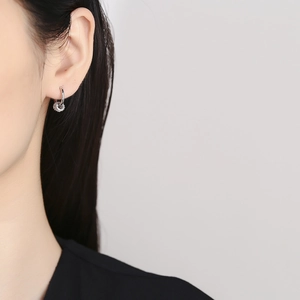 Elegant 925 sterling silver hoop earrings with cubic zirconia on a model's ear