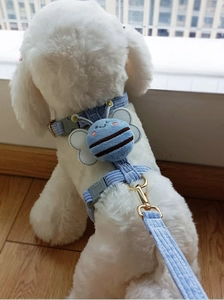 Close-up of light blue corduroy dog harness with 3D plush bee decoration detail