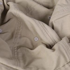 Detail of khaki ripstop fabric with neat stitching and embroidered ventilation holes