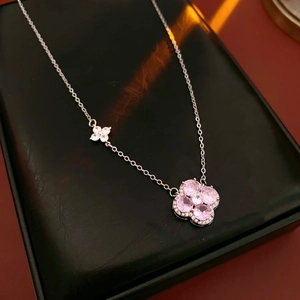 Macro shot of silver four-leaf clover pendant with pink zircons in a jewelry box