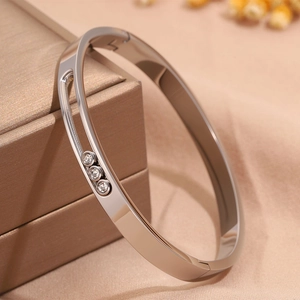 Detailed macro of rose gold titanium bangle featuring three sliding crystals in a groove