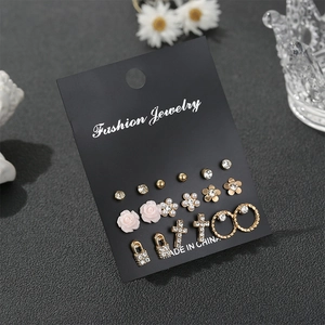 Detail of 9-pair earring set featuring gold metal flowers, pink resin, and crystal studs