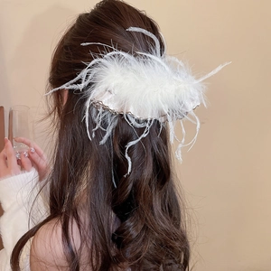 Close-up detail of white feather acrylic hair clip on model showing soft texture and elegant style