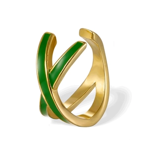 Detail of cross-over open ring with gold finish and green enamel accents on white background