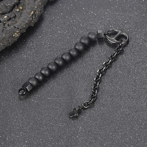Detail of matte black beads joined with a chain and iconic pig nose buckle clasp