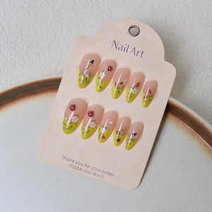 Detailed almond press-on nails featuring 3D ladybugs, floral patterns and green French tips