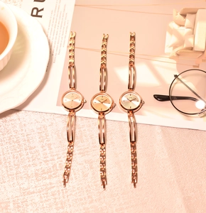 Three rose gold quartz watches with JW logo and metal chain straps in a flat lay view
