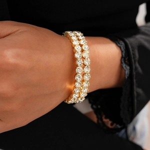 Close-up of double-row gold-plated tennis bracelet with sparkling zircon stones