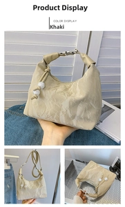 Detail view of khaki pleated hobo bag with white bead accents and silver metal buckles