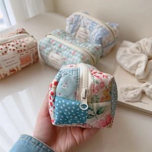 Close-up of quilted cotton makeup bags in floral, plaid, and polka dot patterns