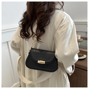 Detail of black matte leather shoulder bag with gold metal twist lock and chain strap
