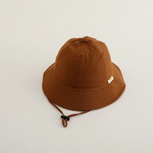 Vue détaillée du chapeau de soleil caramel pour enfants avec cordon et étiquette