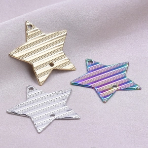 Detailed view of three stainless steel star charms in gold, silver, and rainbow plating