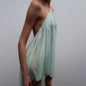 Vue détaillée de la robe dos nu vert menthe avec tissu plissé transparent et élégant