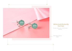 Close-up of S925 silver rabbit stud earrings with green jade beads on pink background