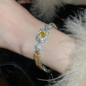 Close-up of a zircon flower bracelet with yellow oval crystals on a fuzzy white sleeve