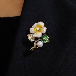 Floral enamel brooch with crystals and pearl on a black suit jacket lapel