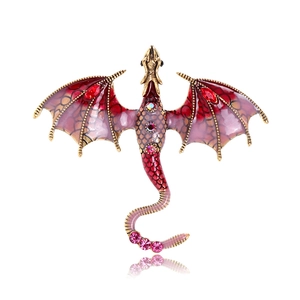 Detailed macro view of vintage dragon brooch with red enamel wings and colorful rhinestones