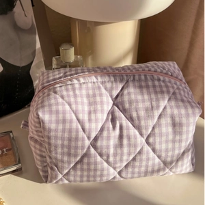 Quilted cotton plaid makeup bag in purple with pink zipper on a cozy vanity desk
