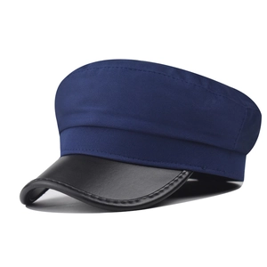 Detail of the navy blue textured fabric and black leather brim on the captain style hat