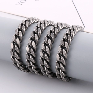 Close-up of vintage black stainless steel Cuban link chain wrapped on a display stand