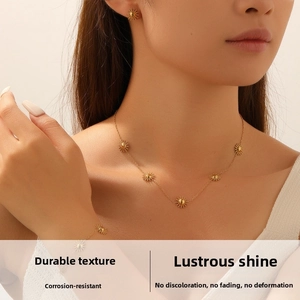 Close-up of a model wearing polished gold sunburst necklace, earrings, and bracelet set