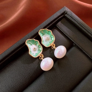 Boucles d'oreilles vintage fleurs vertes émaillées avec perles dans un écrin à bijoux noir