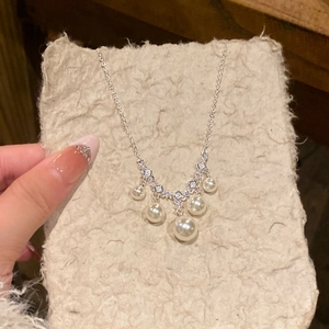 Macro view of French vintage pearl necklace with square zircon accents and silver chain