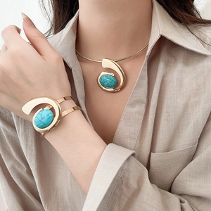 Detail view of vintage gold necklace and bracelet set with turquoise stones on a model