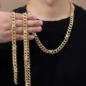 Detail of gold barbed wire Cuban link necklace and bracelet set on male model