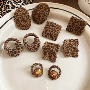 Detail of leopard print earrings with flocked velvet texture and golden zircon inlay