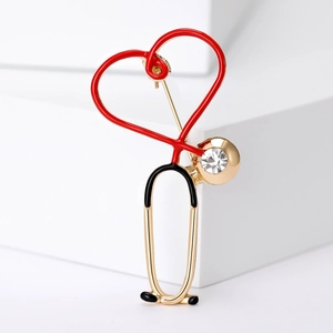 Macro view of stethoscope heart brooch with crystal inlay on a geometric stand