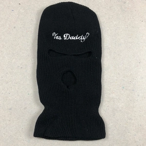Close-up of black 3-hole knitted ski mask with white Yes Daddy embroidery