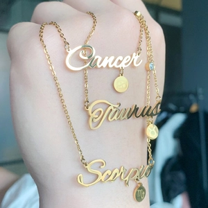 Detailed close-up of golden zodiac necklaces featuring Cancer, Taurus, and Scorpio charms