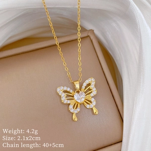 Detailed view of golden butterfly pendant with sparkling crystals and heart centerpiece