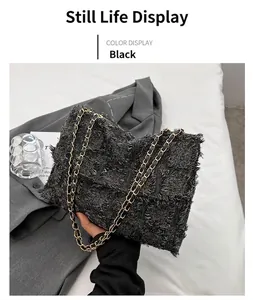 Detail of black tweed crossbody bag with woven texture and gold chain strap