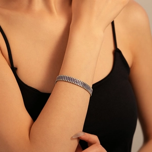 Élégant bracelet tennis à trois rangées de zircons violets et blancs porté au poignet