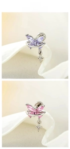 Detail of butterfly earrings with purple and pink zircon and hanging cross pendants
