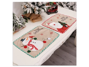 Detailed view of linen Christmas placemats with festive snowman and Santa Claus embroidery