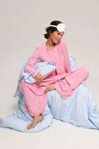 Détail de la texture pyjama rose à motifs cœurs avec masque de sommeil assorti