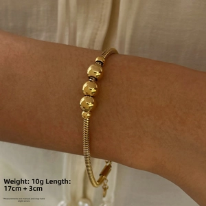 Detail of gold beaded bracelet on wrist showing length of 17cm plus 3cm extension chain