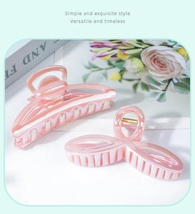 Detailed view of two pink jellyfish jelly hair claws with a glossy laser finish texture