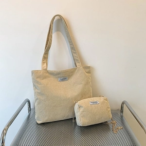 Minimalist beige corduroy tote bag set with matching chain pouch on a metal shelf