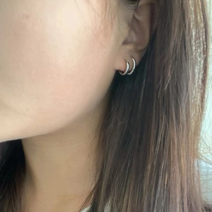 Minimalist silver titanium steel double hoop earrings shown on a female model