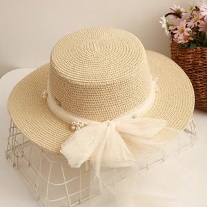 Flat top straw sun hat for women featuring a large mesh bow and elegant pearl accents