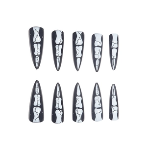Macro shot of 10-piece stiletto press-on nails with white skeleton finger bone patterns