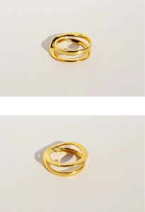 Detail view showing dual-layer irregular gold lines on a modern minimalist crossing ring