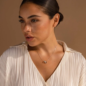 Silver interlocking double hoop necklace featuring opal accents worn on woman neck